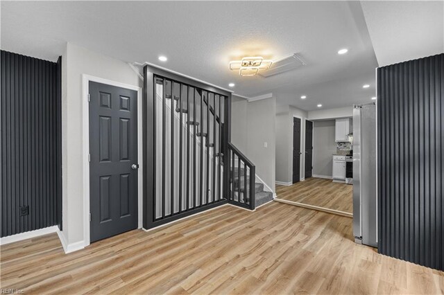 entryway with light wood-type flooring, baseboards, recessed lighting, and stairway