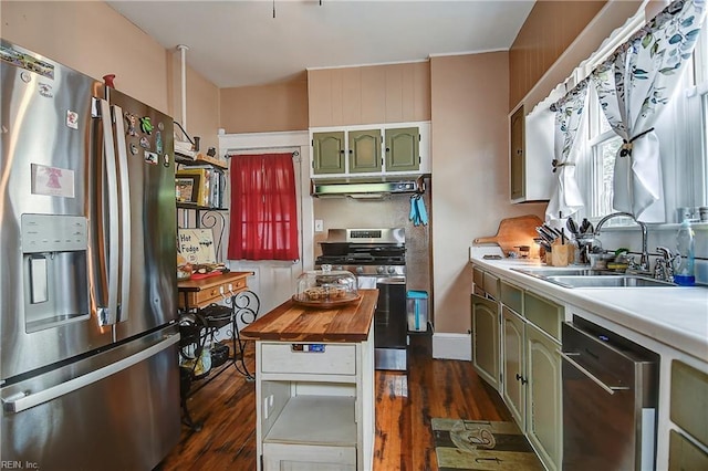 kitchen featuring dark wood-style flooring, green cabinets, stainless steel appliances, and a sink