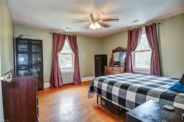 bedroom with light wood-style flooring, visible vents, and multiple windows
