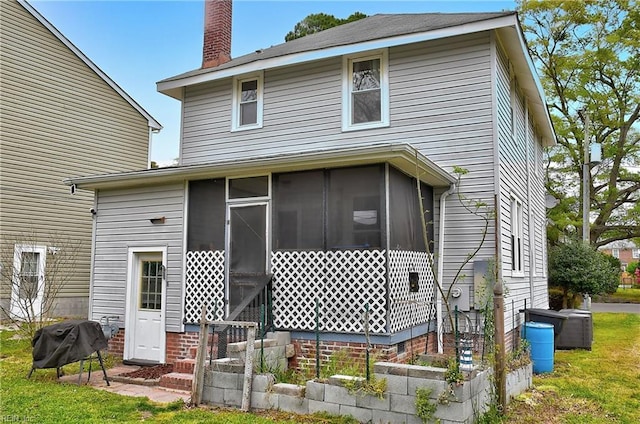 back of property with a sunroom and a chimney