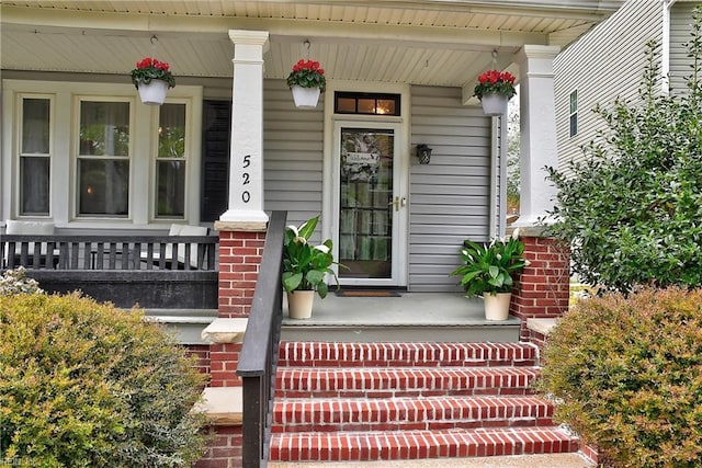 entrance to property with brick siding and covered porch
