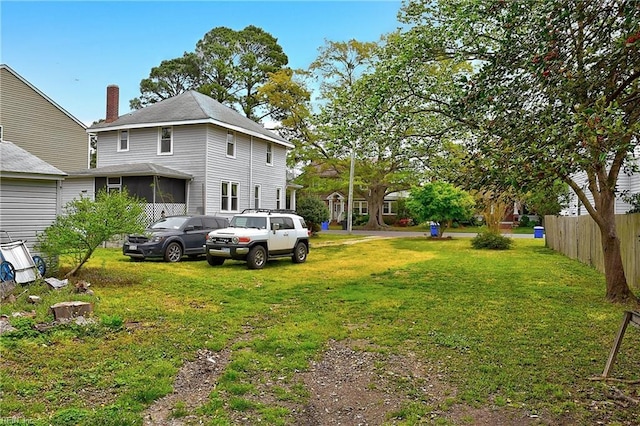 view of yard with fence and a sunroom