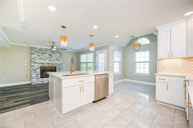kitchen with a sink, open floor plan, dishwasher, a tiled fireplace, and light countertops
