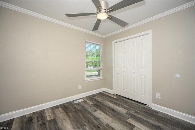 unfurnished bedroom featuring dark wood-style flooring, visible vents, baseboards, and ornamental molding