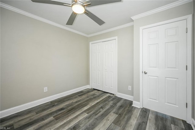unfurnished bedroom featuring dark wood-style flooring, a closet, ceiling fan, baseboards, and ornamental molding
