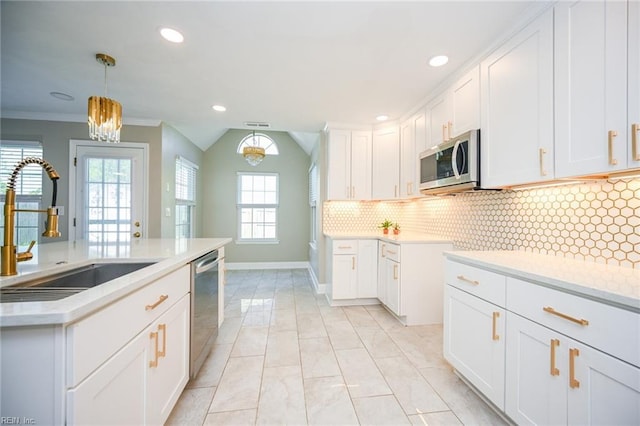 kitchen featuring white cabinets, stainless steel appliances, light countertops, and a sink