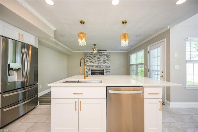 kitchen with plenty of natural light, a ceiling fan, a sink, and appliances with stainless steel finishes