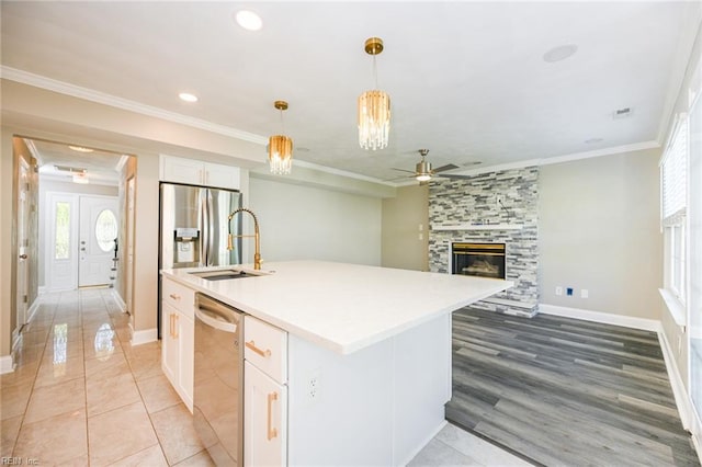 kitchen featuring white cabinets, ceiling fan, ornamental molding, and stainless steel appliances