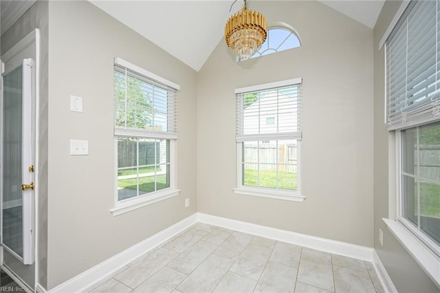 interior space with a wealth of natural light, baseboards, vaulted ceiling, and an inviting chandelier