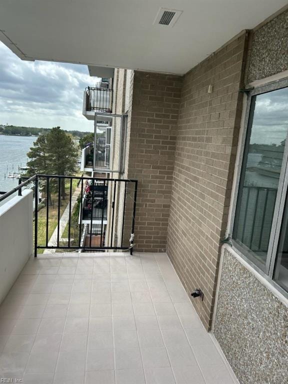 balcony with visible vents and a water view