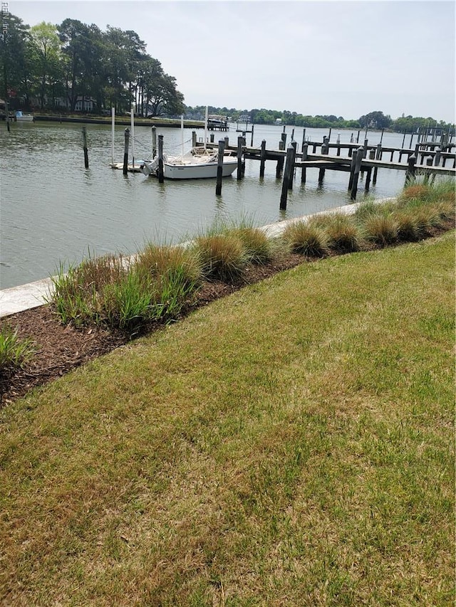 view of dock featuring a yard and a water view