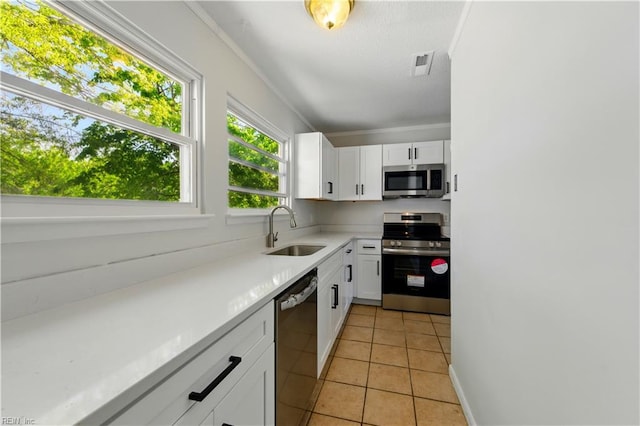 kitchen featuring white cabinets, light tile patterned flooring, stainless steel appliances, and a sink