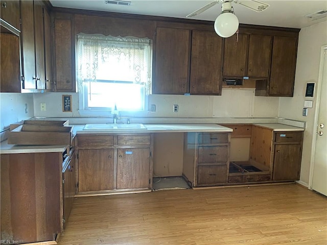 kitchen featuring a sink, visible vents, and light wood-type flooring