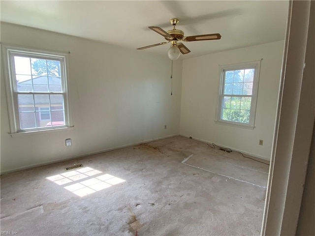 spare room featuring carpet floors, a ceiling fan, and baseboards