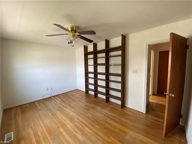 unfurnished room featuring light wood-type flooring, baseboards, a ceiling fan, and visible vents