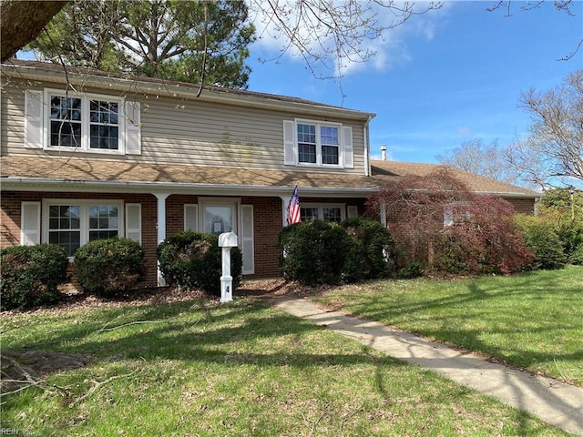 traditional-style house with a front lawn and brick siding