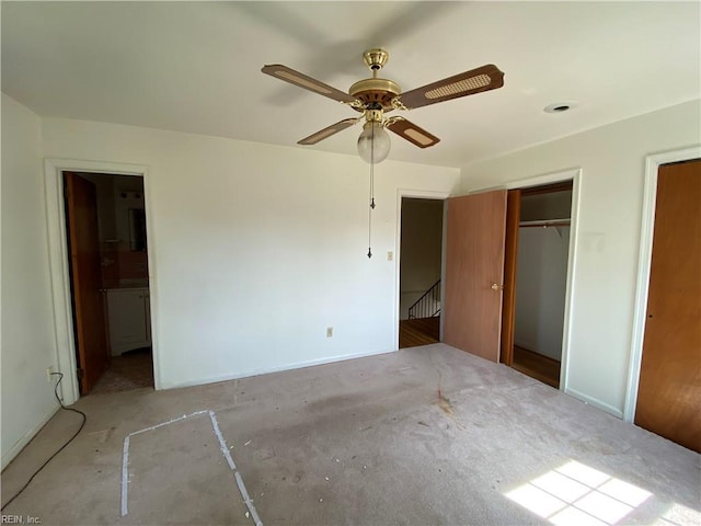 unfurnished bedroom featuring a closet, ceiling fan, and connected bathroom