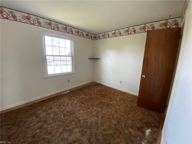 carpeted empty room with visible vents and baseboards