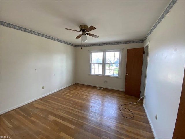 unfurnished room with baseboards, a ceiling fan, and wood finished floors
