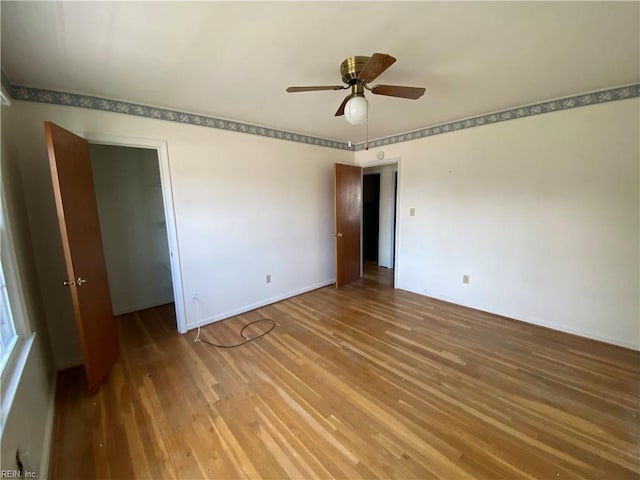 unfurnished bedroom with ceiling fan, baseboards, and wood finished floors