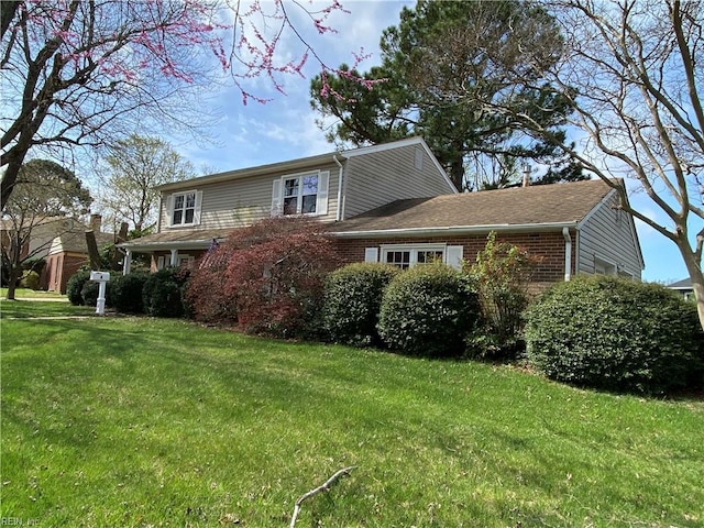 view of front of house featuring brick siding and a front yard