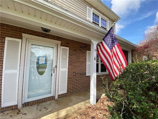 property entrance featuring brick siding