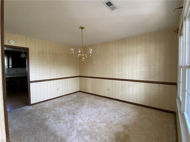 unfurnished room with a chandelier, wallpapered walls, visible vents, and baseboards