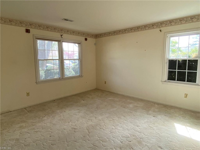 empty room with visible vents and light colored carpet