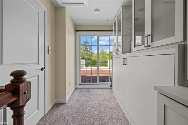 entryway featuring baseboards, visible vents, and light colored carpet