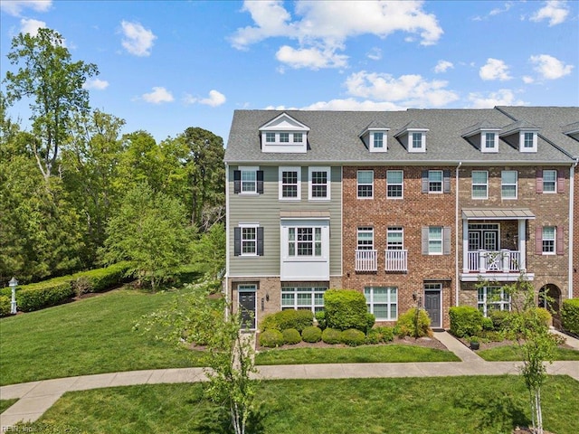 view of property with a front yard and brick siding