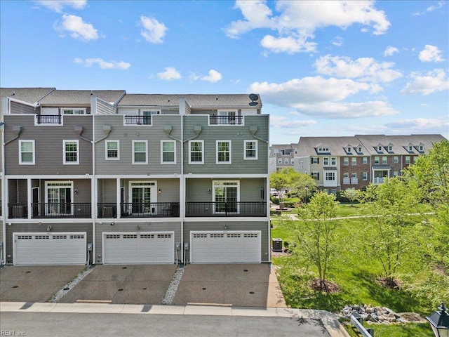 view of front of house featuring a residential view, driveway, and an attached garage