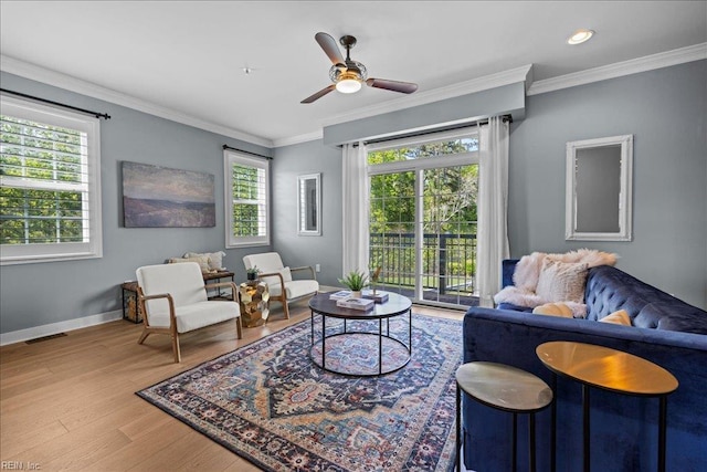 living room featuring visible vents, wood finished floors, ceiling fan, and ornamental molding