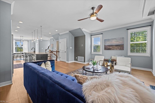 living room featuring ornamental molding, visible vents, and baseboards
