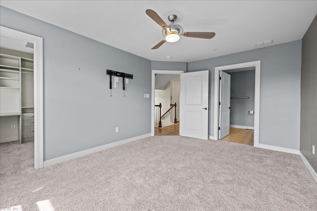 unfurnished bedroom with baseboards, visible vents, a spacious closet, and carpet