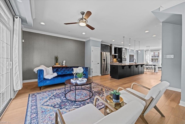 living room with recessed lighting, a ceiling fan, light wood-style flooring, baseboards, and an accent wall
