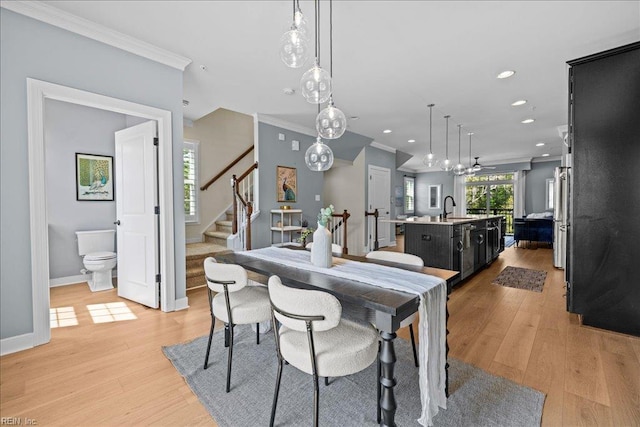 dining space featuring light wood finished floors, recessed lighting, stairs, baseboards, and ornamental molding