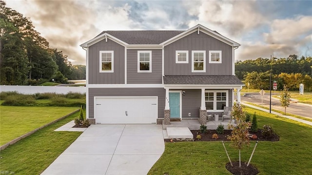 craftsman house featuring driveway, board and batten siding, covered porch, an attached garage, and a front yard