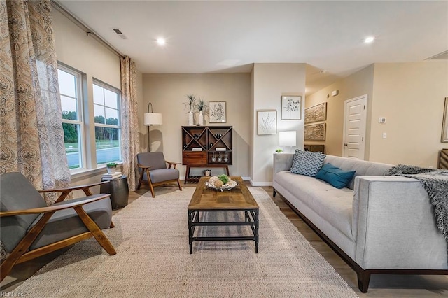 living room with baseboards, wood finished floors, visible vents, and recessed lighting