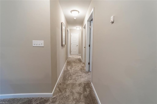 hall with baseboards and carpet flooring