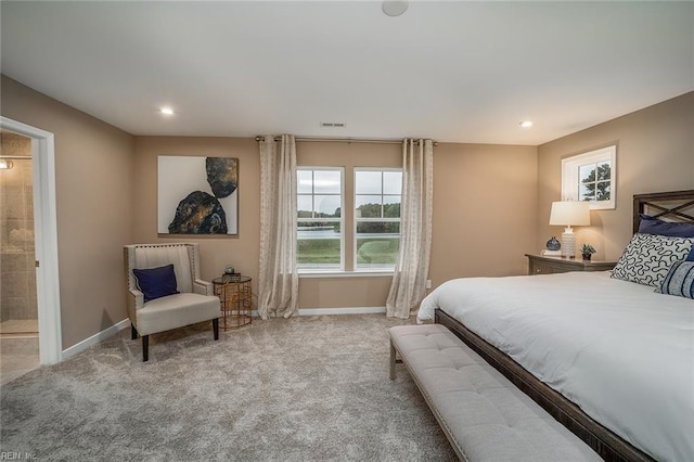 carpeted bedroom featuring baseboards, ensuite bathroom, visible vents, and recessed lighting