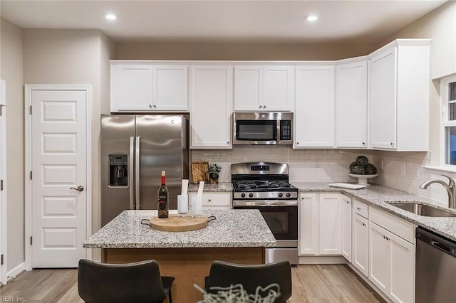 kitchen featuring white cabinets, stainless steel appliances, and a sink