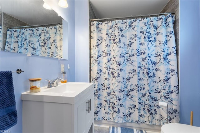 full bath with a shower with curtain, vanity, and toilet