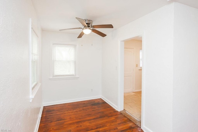spare room with baseboards, a ceiling fan, and wood finished floors
