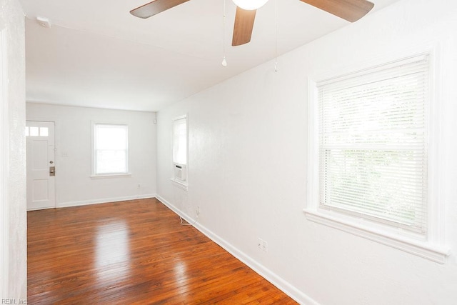 empty room featuring wood finished floors, a ceiling fan, and baseboards