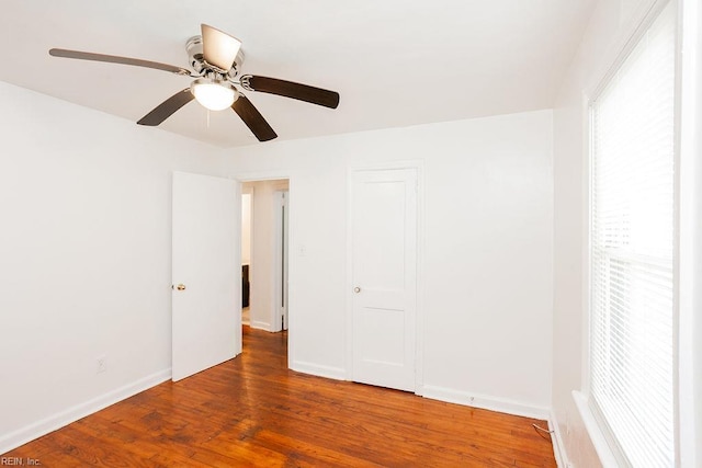 spare room with baseboards, a ceiling fan, and wood finished floors