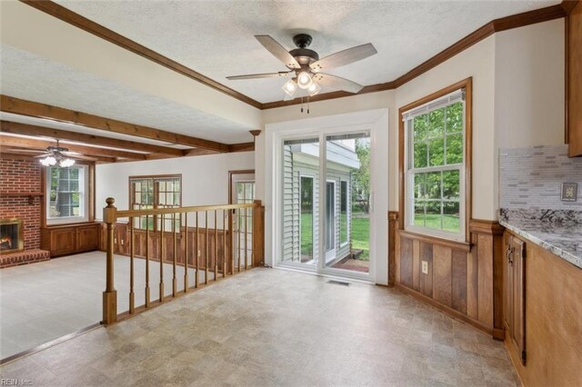 interior space with light floors, ceiling fan, a wealth of natural light, and a textured ceiling