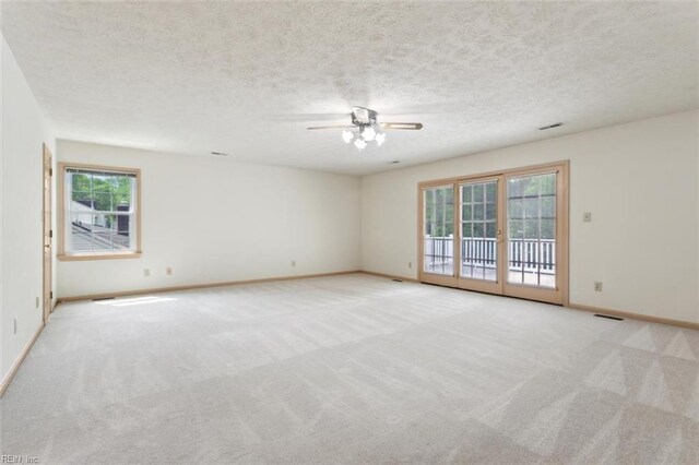 unfurnished room with baseboards, a ceiling fan, carpet flooring, and a textured ceiling