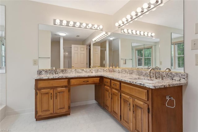 bathroom with baseboards, tile patterned floors, a sink, and double vanity