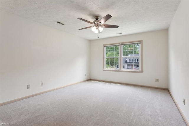 unfurnished room featuring a ceiling fan, a textured ceiling, baseboards, carpet flooring, and visible vents