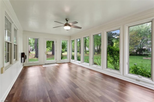 unfurnished sunroom featuring baseboards and wood finished floors